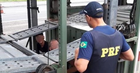 PRF flagra três passageiros no compartimento de carga de cegonheira na BR 101, em Tubarão