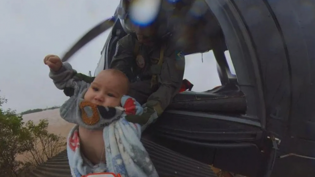 Bebê é resgatado de helicóptero pelo telhado de casa alagada no RS