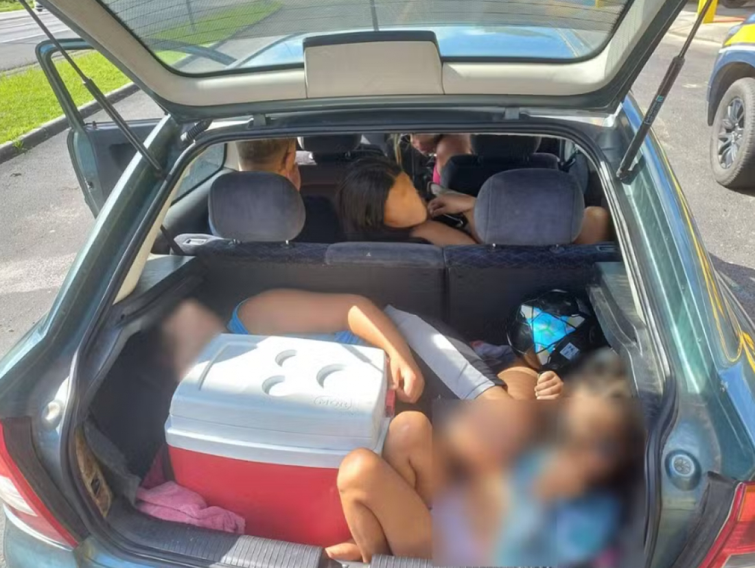 Pai é flagrado levando filhos no porta-malas de carro dividindo espaço com cooler, sacolas e bola