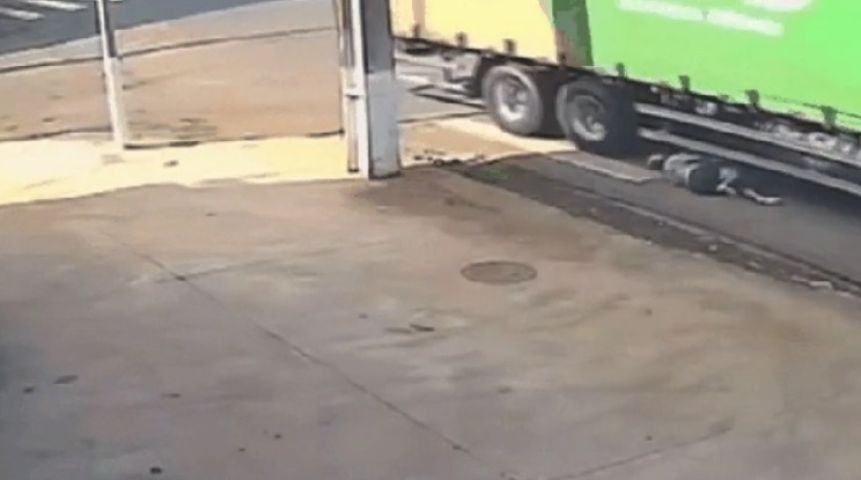 Motociclista rola no asfalto para conseguir se salvar de acidente com caminhão
