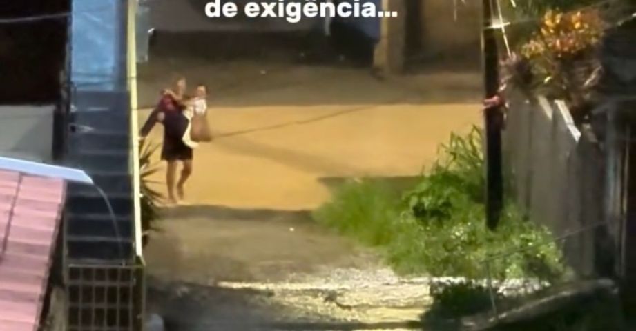 (VÍDEO) Homem carrega esposa no colo para atravessar rua alagada e vídeo viraliza em Pernambuco