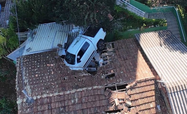 Em SC: motorista sofre mal súbito e caminhonete cai sobre telhado de casa