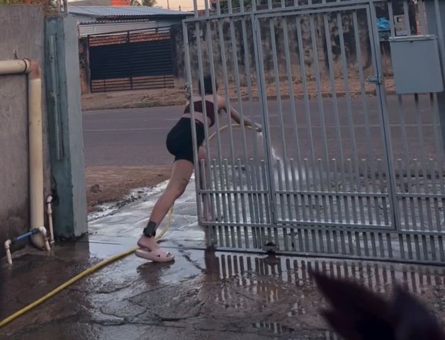 Com tornozeleira, influenciadora viraliza ao lavar calçada sem colocar o pé monitorado na rua; VÍDEO