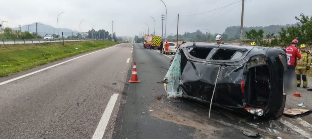 Colisão entre dois veículos deixa carro capotado e uma pessoa ferida na BR-101, em Sangão